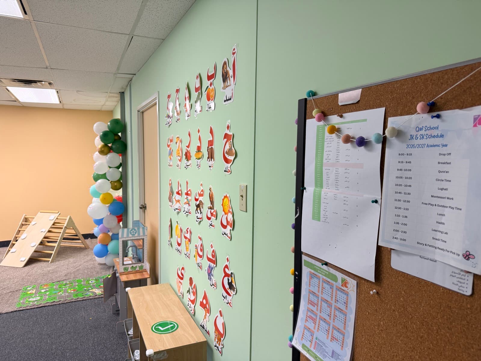 Arabic alphabet wall display beside the class schedule and school calendar board