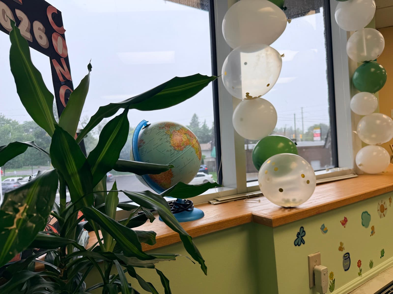 Globe and balloons on a sunny classroom windowsill